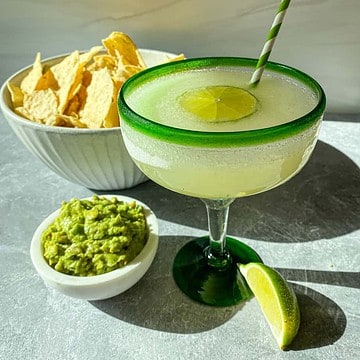 Minute Maid limeade margarita on a table with chips and guacamole.