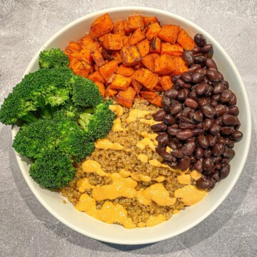 Vegan taco bowl with black beans, broccoli, sweet potatoes, and a cashew cheese sauce.