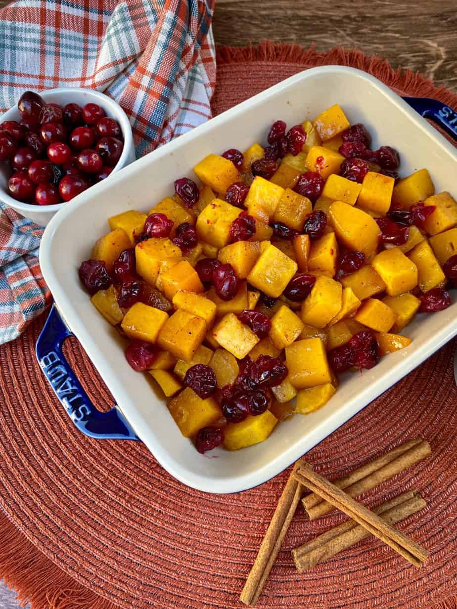 Maple Roasted Butternut Squash and Cranberries with cinnamon sticks as a garnish. Thanksgiving side dish.