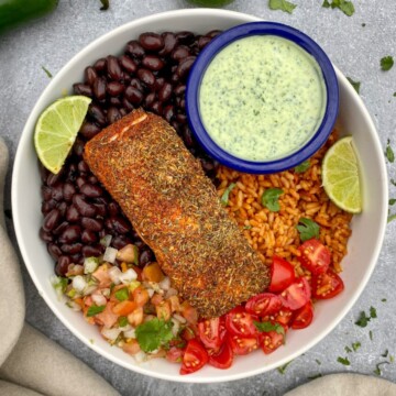 Blackened Salmon Bowl with Creamy Jalapeño Salsa in a bowl with rice, beans, and fresh veggies.