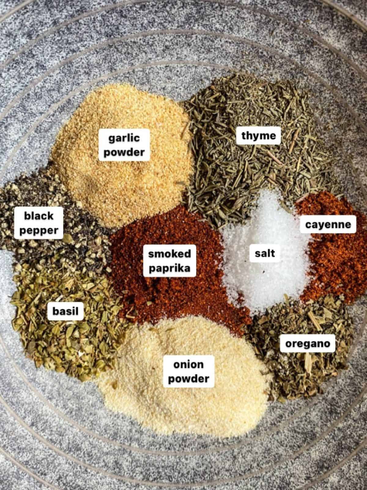 Blackened spices separated in a gray bowl to show each individual spice with each labeled.