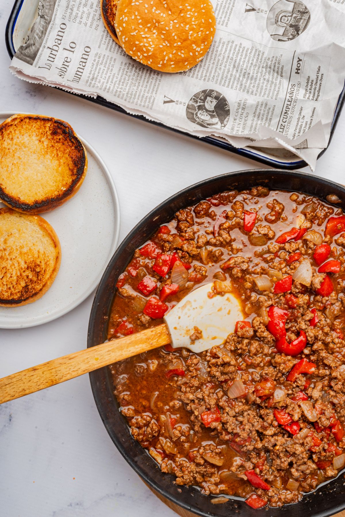 Homemade sloppy joes sauce in a skillet with toasted buns.