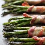 Bacon wrapped asparagus on a sheet pan.