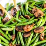 Sautéed green beans and mushrooms in a bowl. A healthy side for sandwiches.
