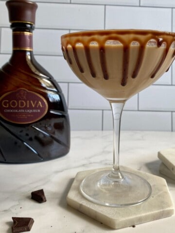 Chocolate Martini with Godiva chocolate liqueur drink sitting on a coaster with the Godiva bottle in the background.