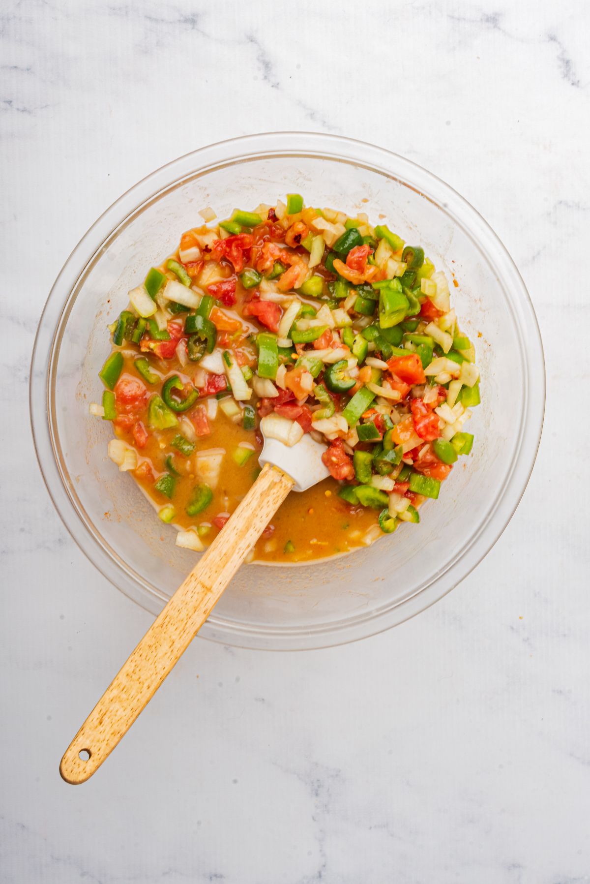 Chopped onions, bell peppers, and jalapenos in a mixing bowl with Campbell's soups.