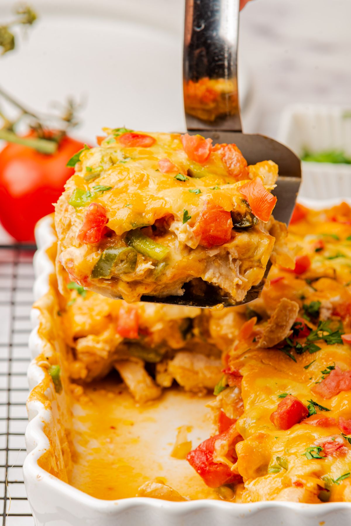 A serving of king ranch chicken casserole on a spatula being removed from the casserole dish.