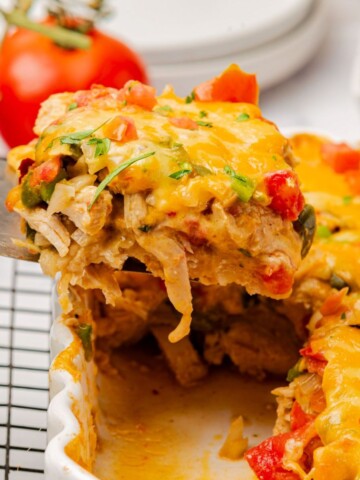 A serving of king ranch chicken casserole on a spatula being removed from the casserole dish.