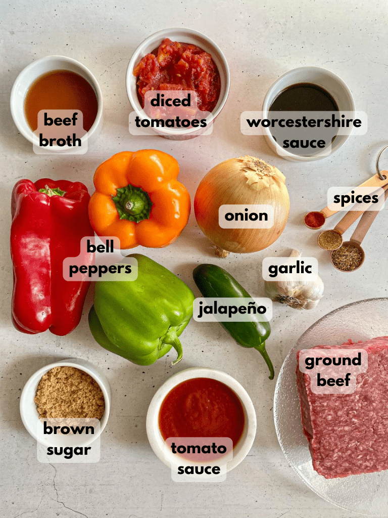 Ingredients needed to make Stuffed Pepper Soup: ground beef, bell peppers, onion, garlic, measuring spoons of spices, tomatoes, and beef broth.