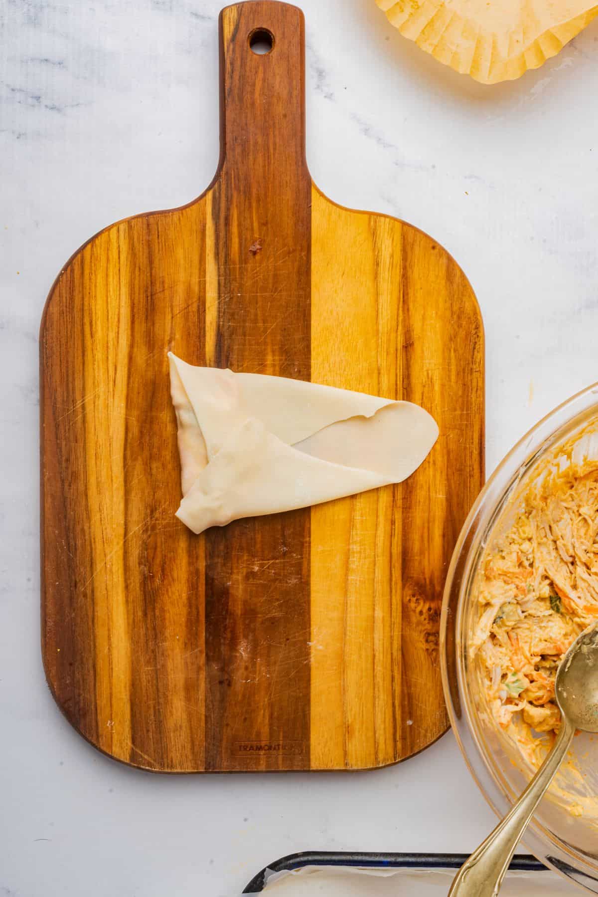 Egg roll wrapped on a cutting board.