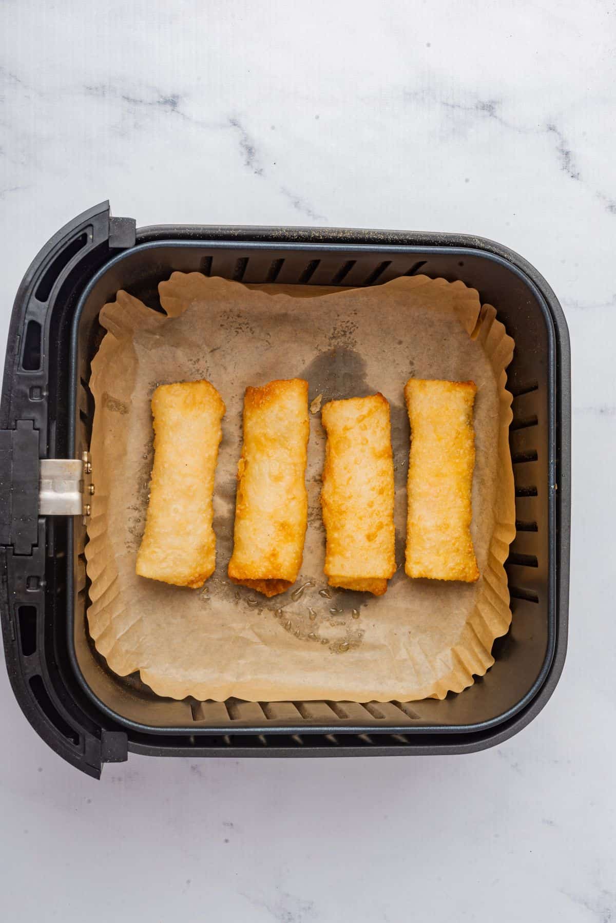 Four egg rolls in air fryer.