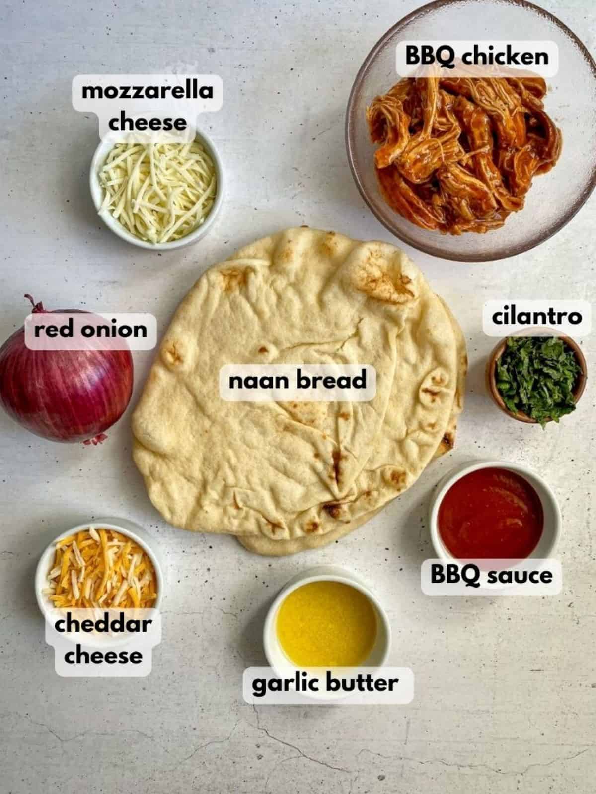 Ingredients needed to make BBQ chicken flatbread: naan bread, barbecue chicken, cheese, cilantro, bbq sauce, and garlic butter.