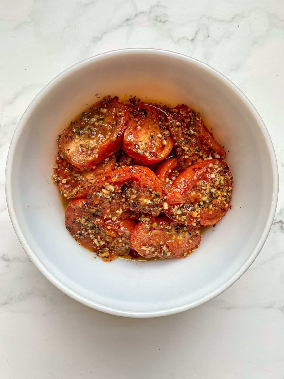 Roasted Roma tomatoes in a large bowl.