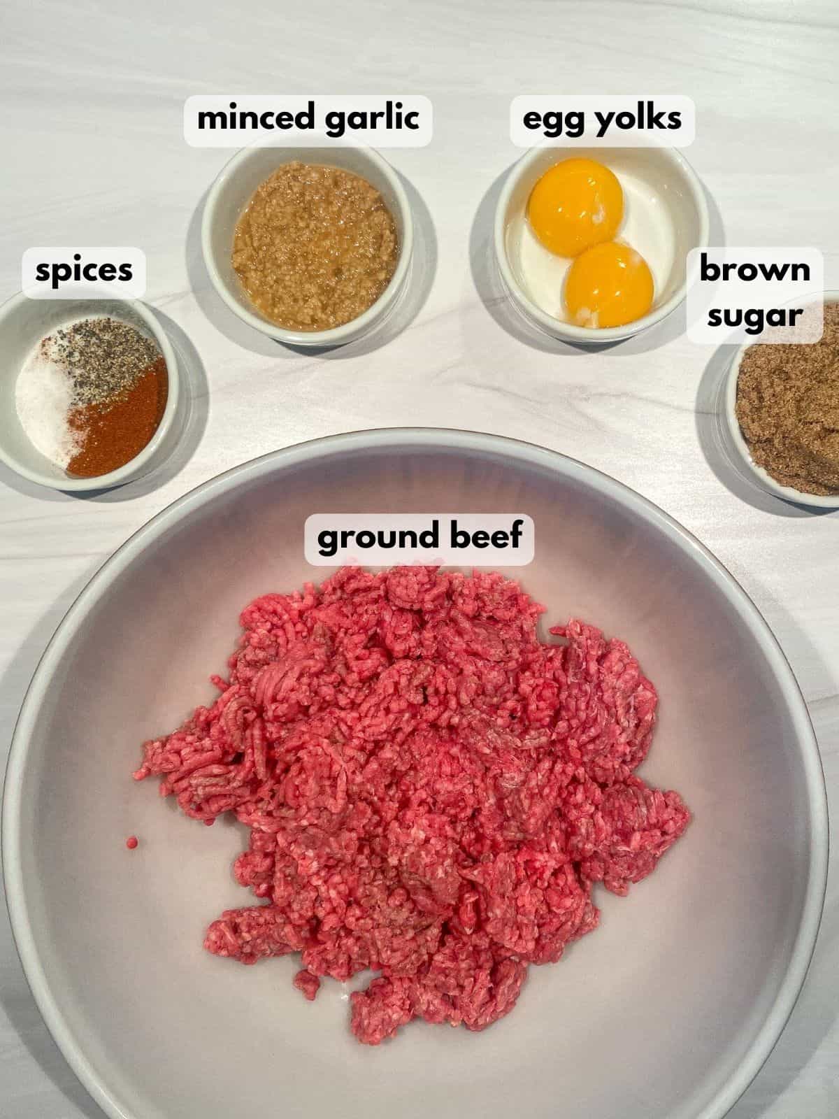 Ingredients for the best burger recipe: ground beef, egg yolks, spices, garlic, and brown sugar.