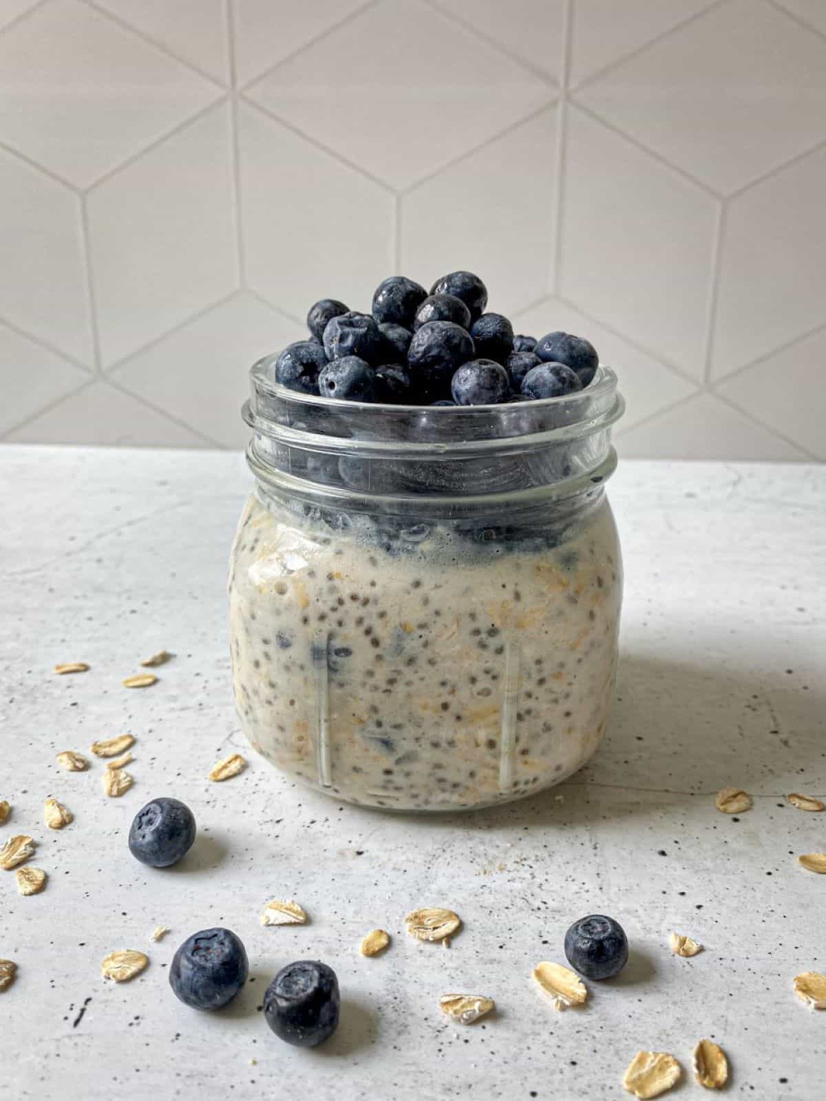 Blueberry Overnight Oatmeal in a mason jar topped with fresh blueberries.