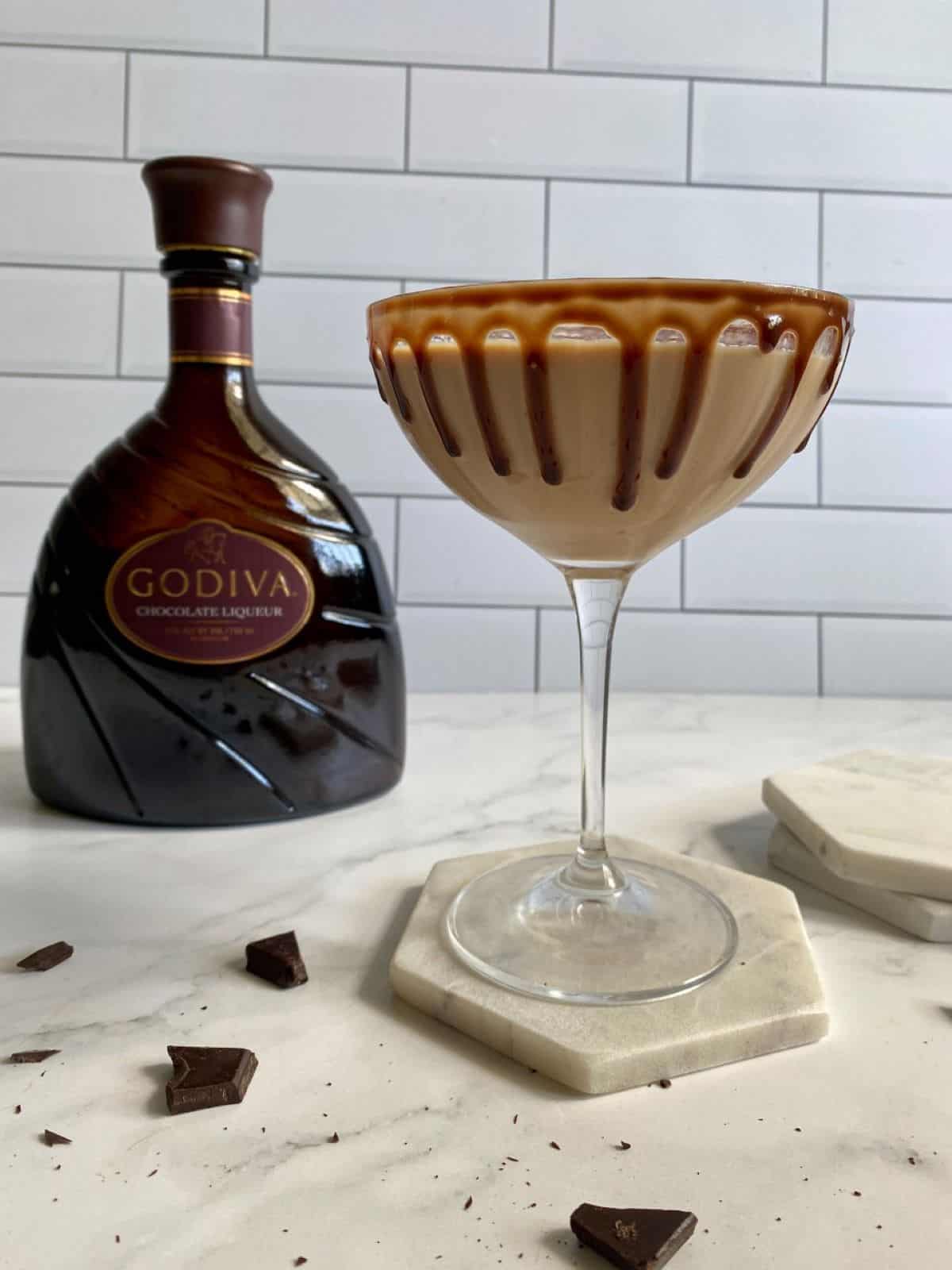 Chocolate Martini with Godiva chocolate liqueur drink sitting on a coaster with the Godiva bottle in the background.