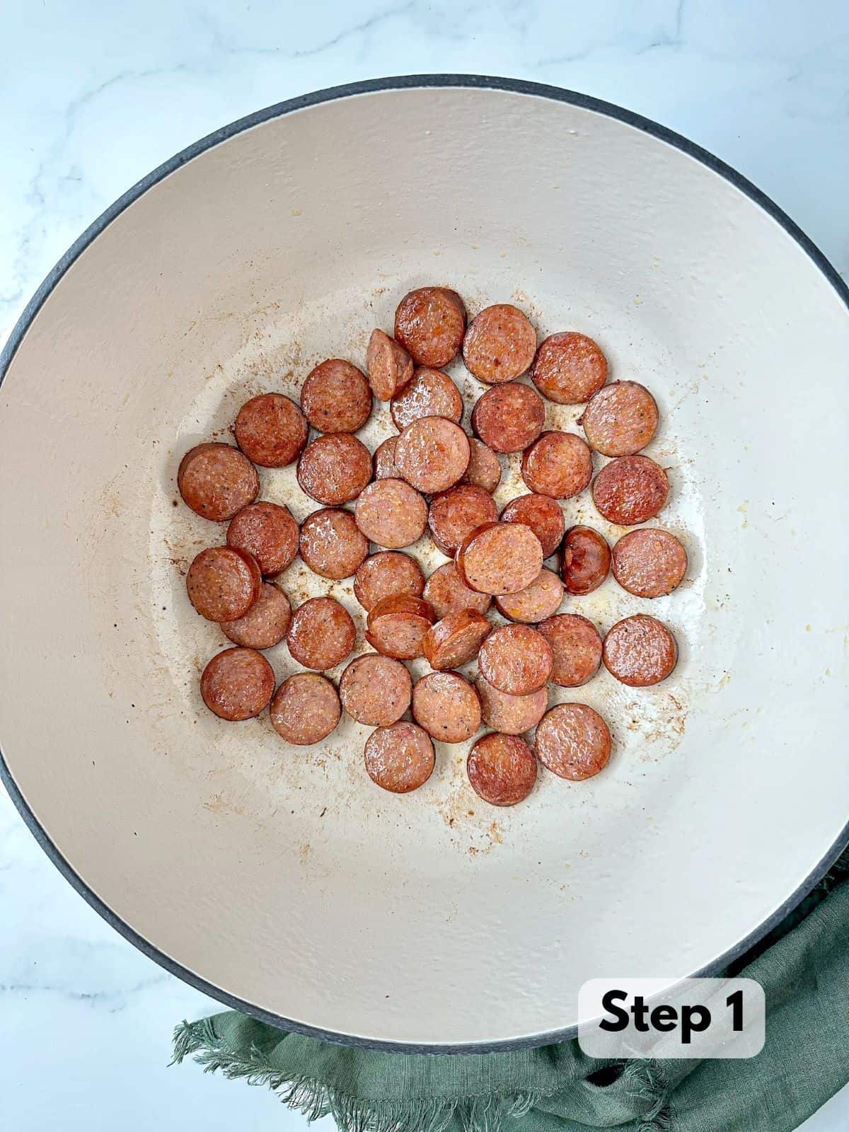 Andouille sausage browned in a large Dutch oven.