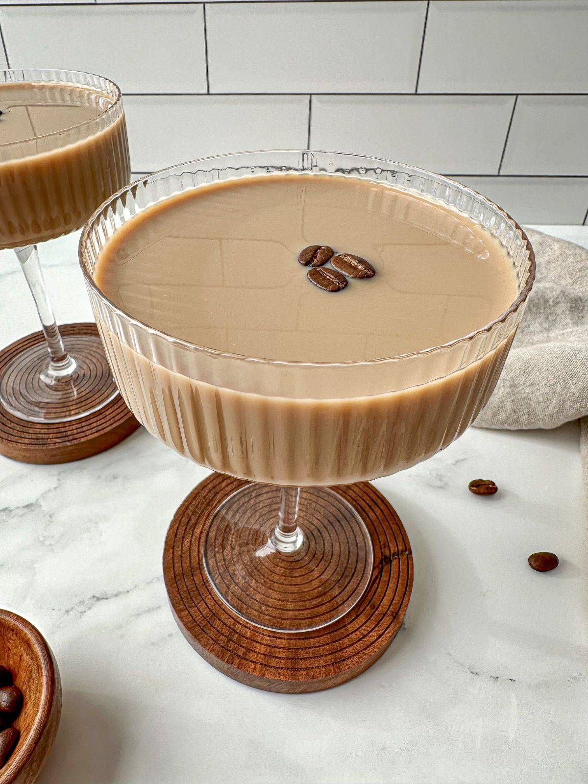 A creamy coffee martini with Baileys in a cocktail glass topped with three coffee beans.