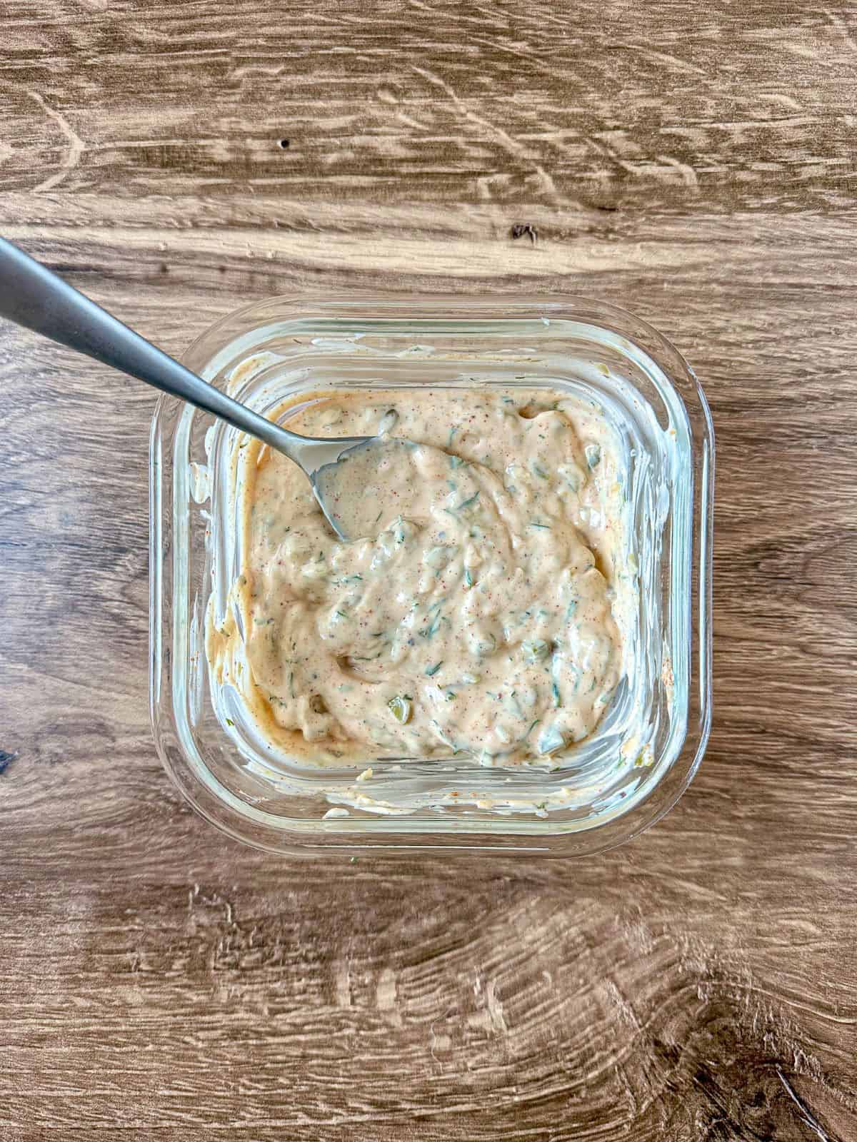 Sauce ingredients combined and mixed together with a spoon in the mixing bowl.