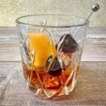 Brown sugar old fashioned in a rocks glass with a cherry and orange peel garnish.