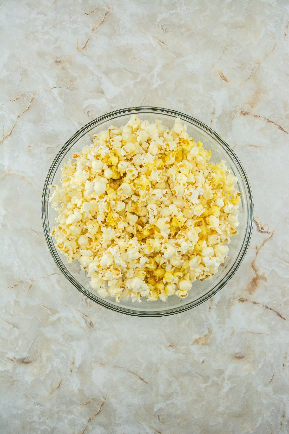 Melted butter drizzled on top of popcorn in a bowl.