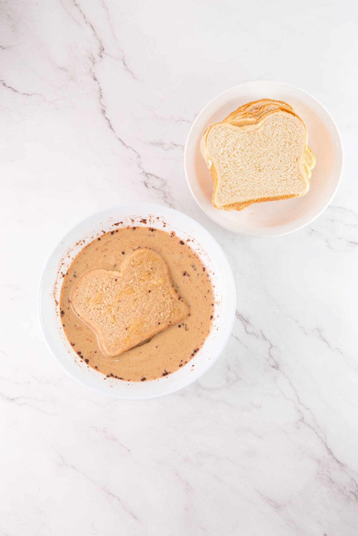 Brioche bread soaking in tiramisu French toast custard mixture.