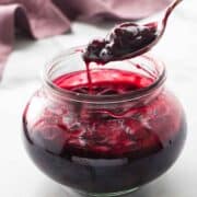 Cherry compote in a bowl with a spoon.