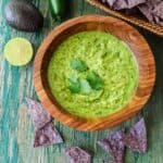 Green avocado shrimp taco sauce in a wooden bowl.