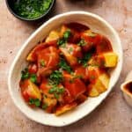 Spanish patatas bravas with red sauce in a serving bowl.