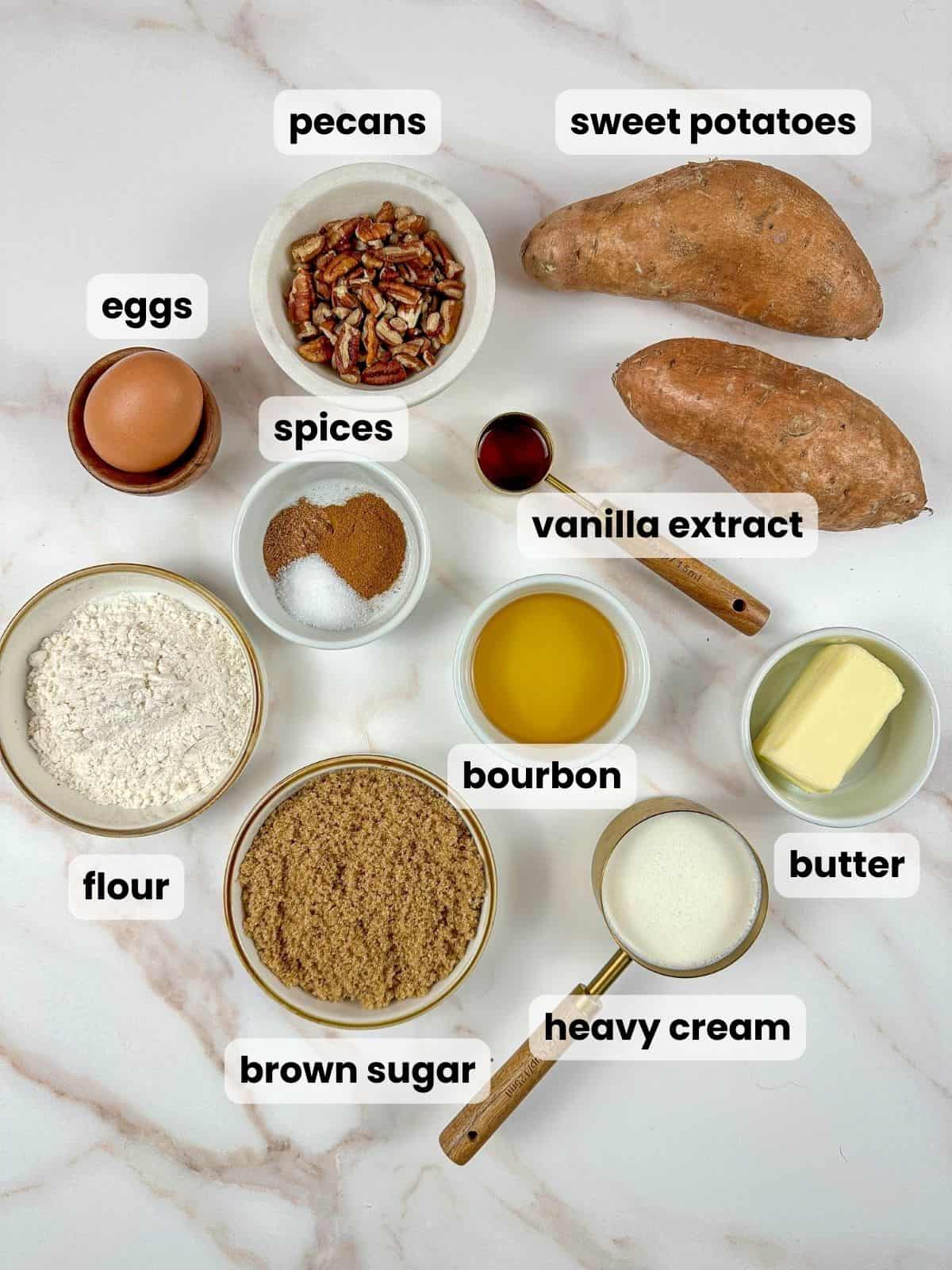 Ingredients needed to make a bourbon sweet potato casserole recipe are on a marble countertop.