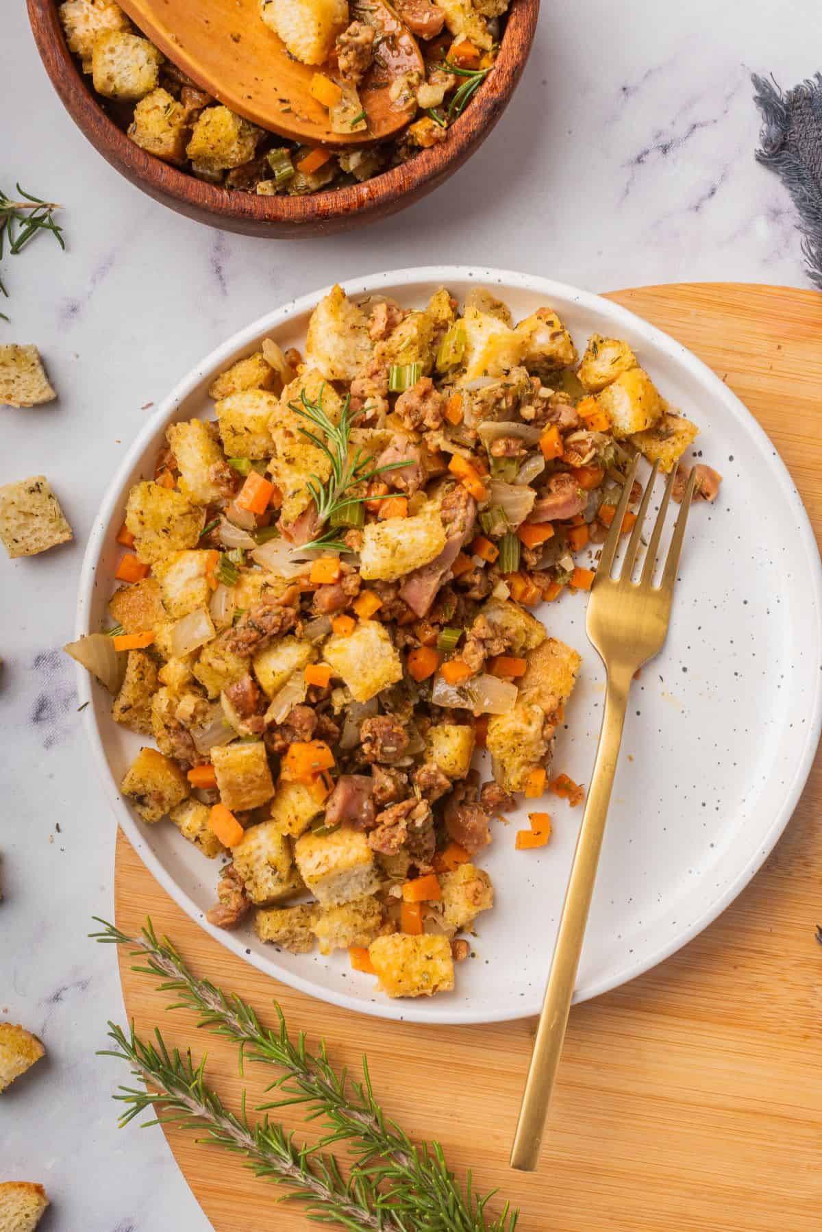 Stovetop sausage stuffing on a white plate with a fork.