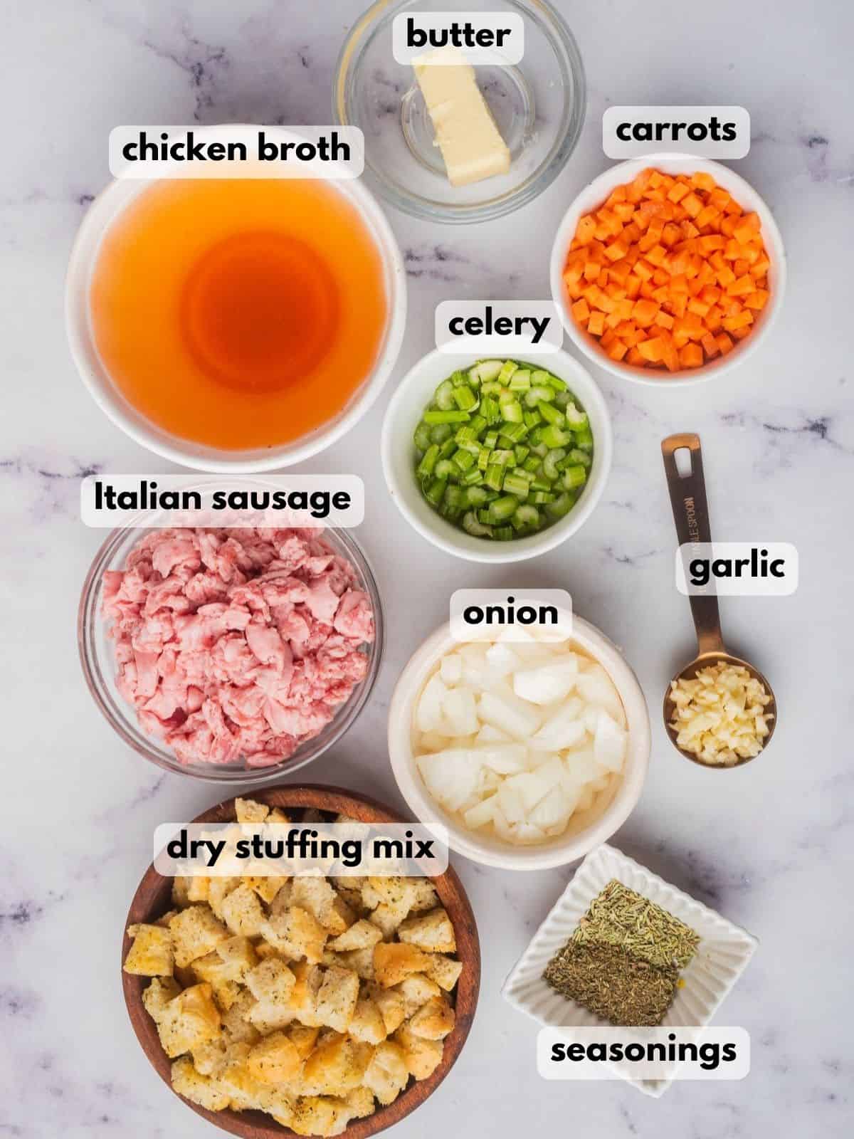 Ingredients needed to make Stove Top stuffing with sausage are in bowls on a marble kitchen counter.