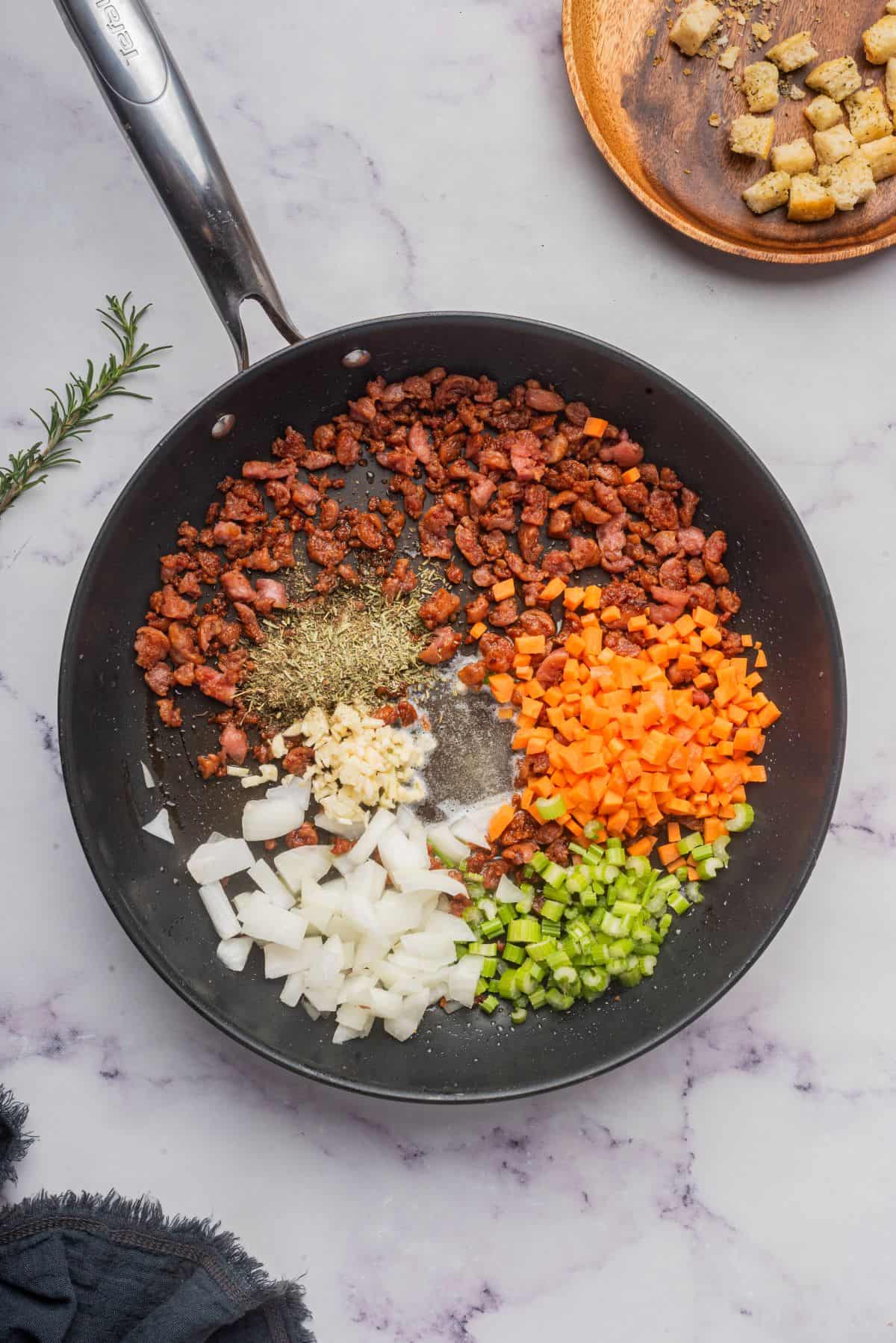 Ground Italian sausage with chopped onions, carrots, and celery in a large skillet.