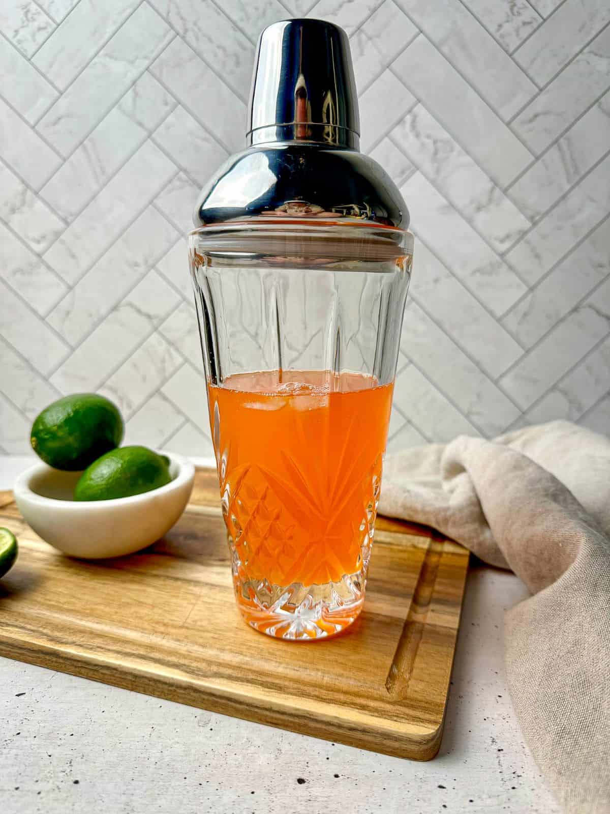 Tequila and Aperol with triple sec and lime juice in a cocktail shaker.