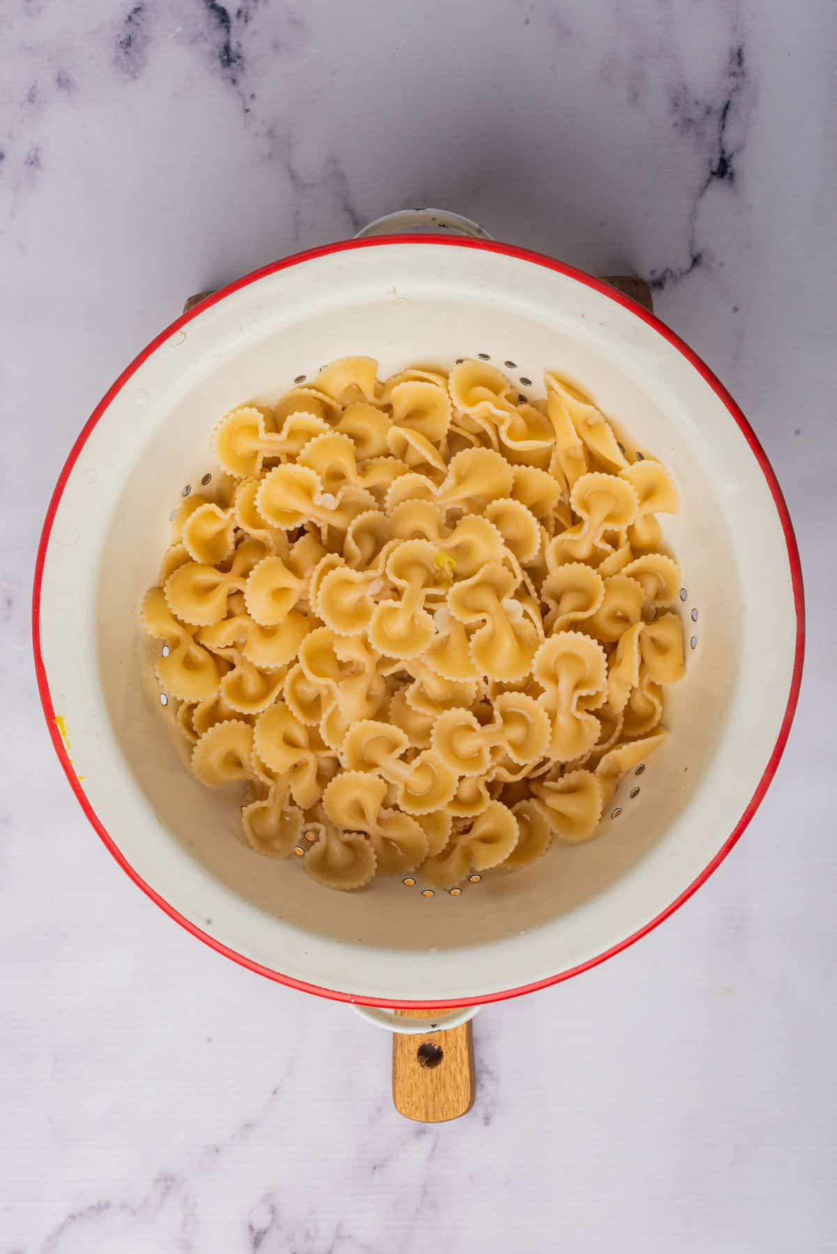 Bowtie pasta, or farfalle pasta, drained in a colander.