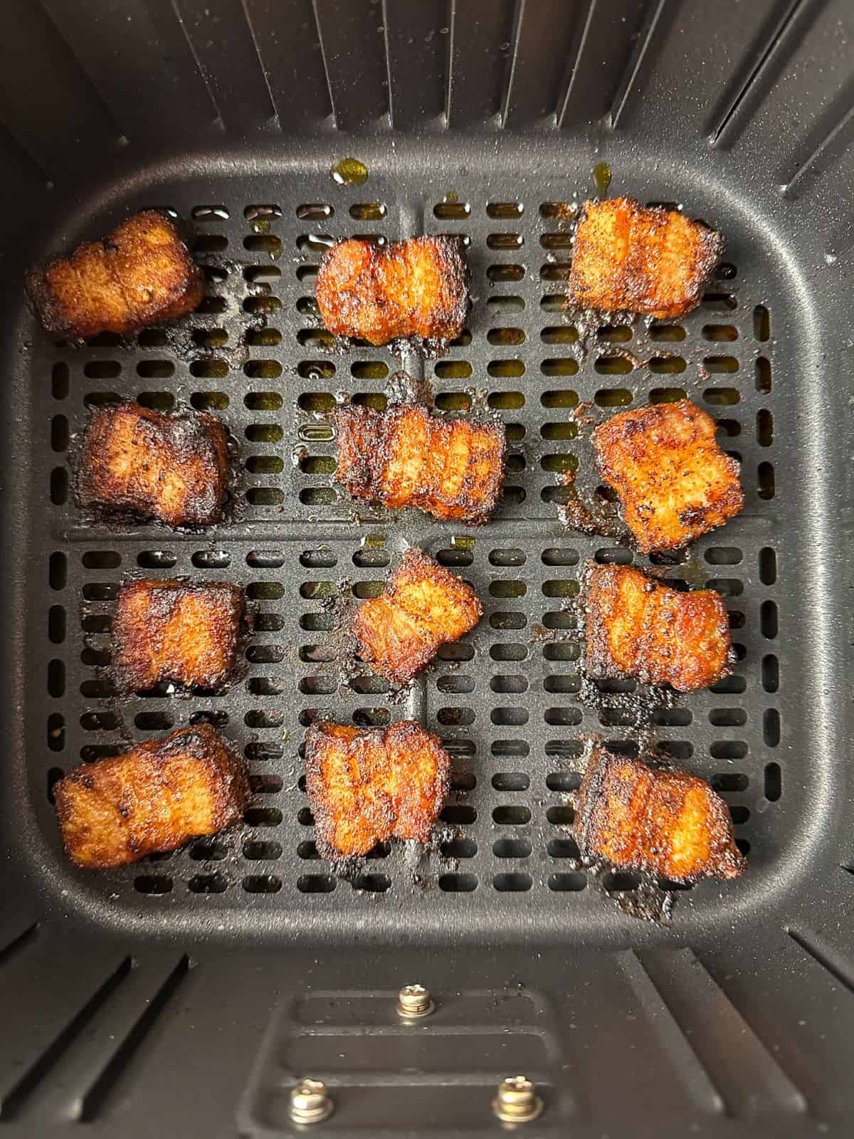 Crispy air fried pork belly in an air fryer basket.