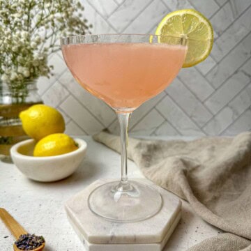 A lavender lemon drop martini in a cocktail glass.