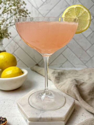 A lavender lemon drop martini in a cocktail glass.