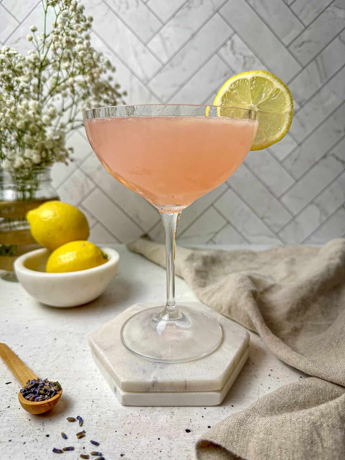 A lavender lemon drop martini in a cocktail glass.