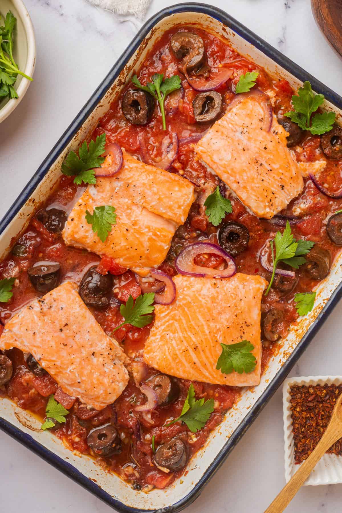 Salmon puttanesca in a baking dish.