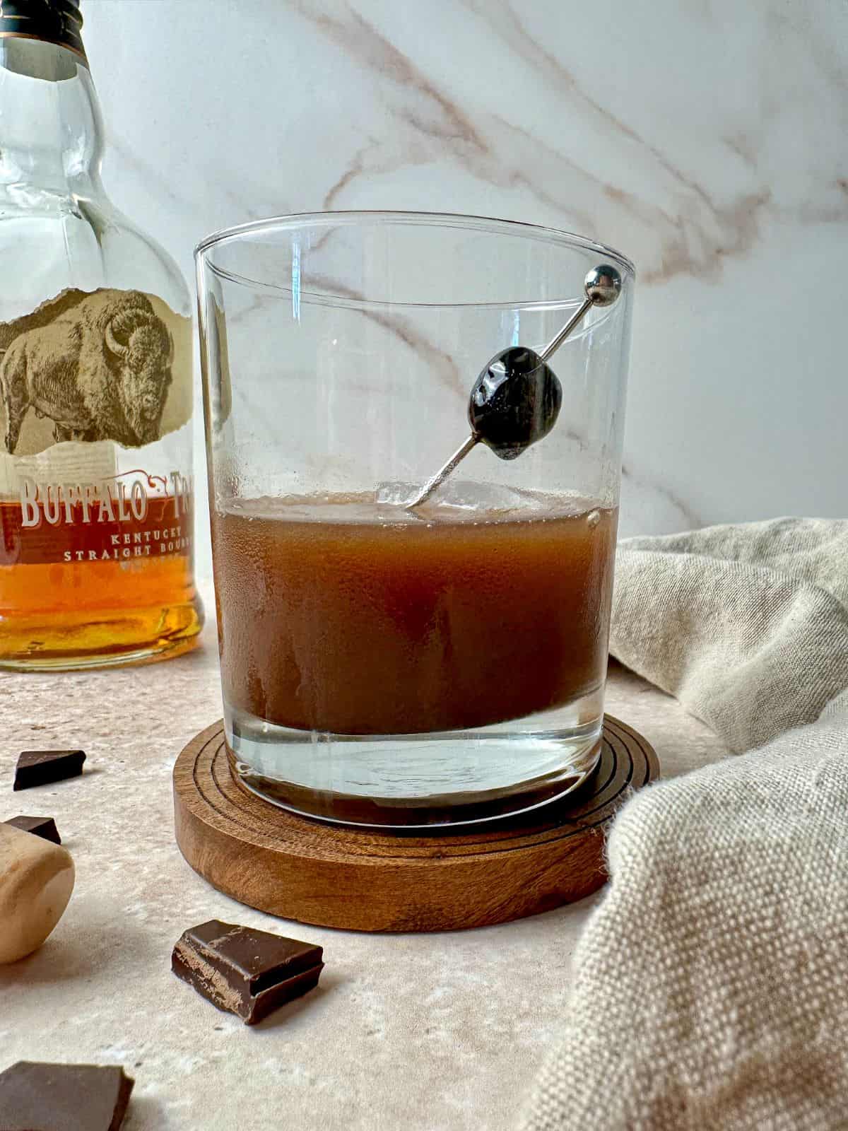 Chocolate old fashioned in a rocks glass with a cherry garnish.