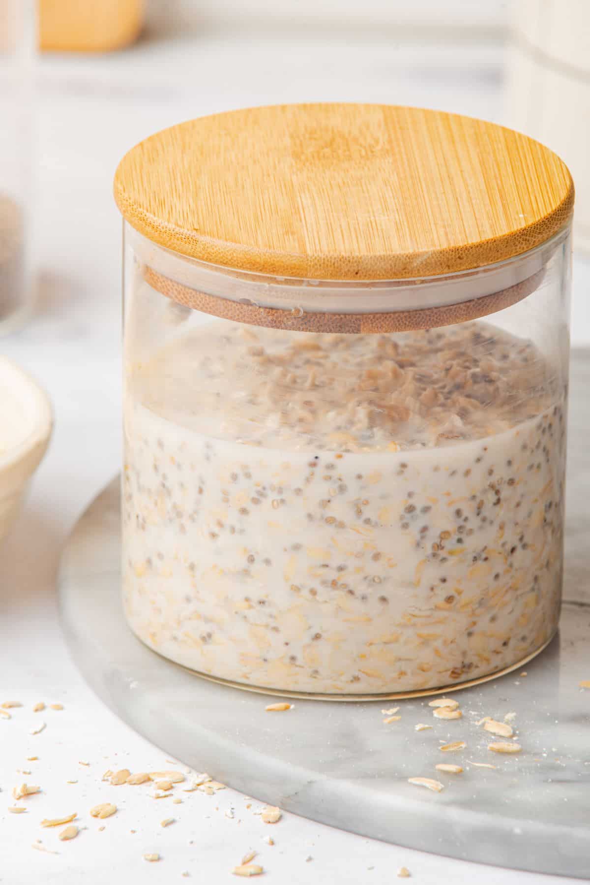 Vanilla oatmeal in a glass jar with a wooden lid.