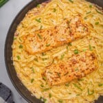 Cajun salmon pasta in a skillet topped with chives.