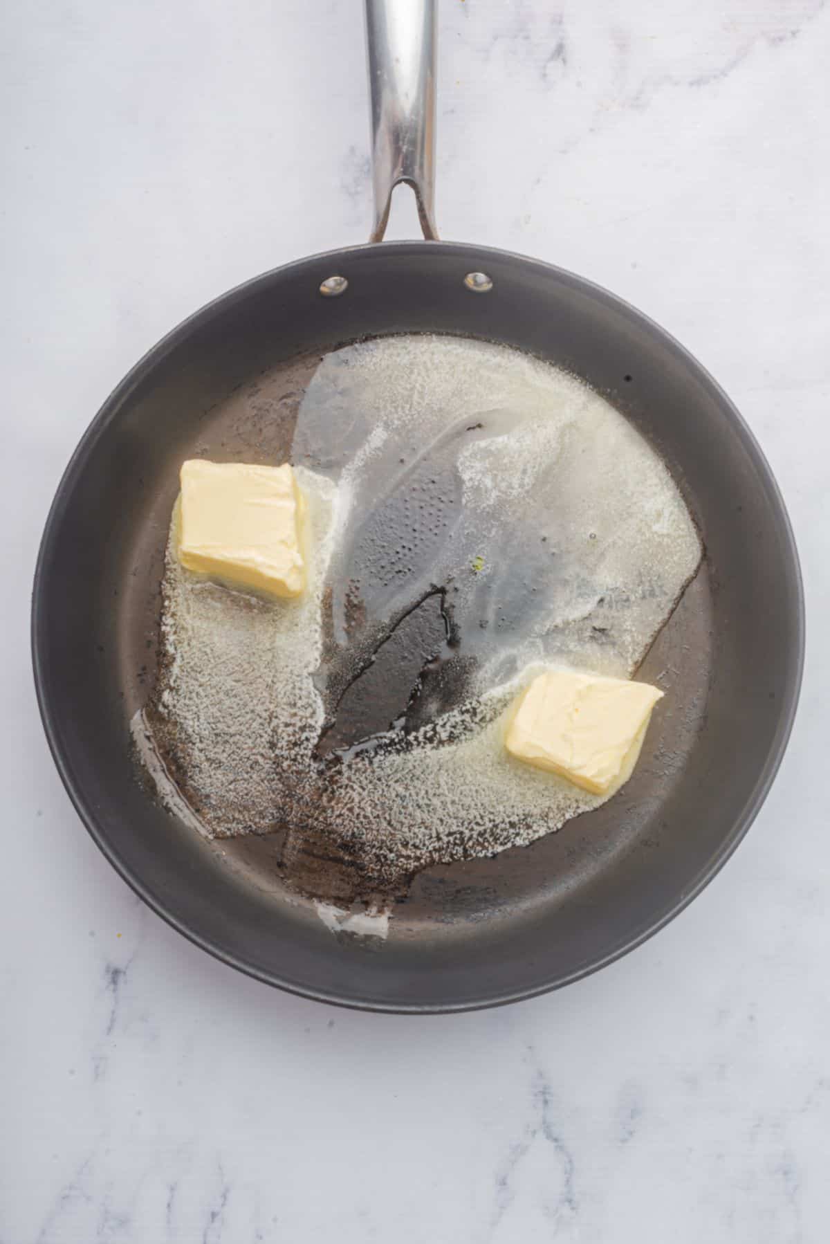 Butter melting in a large skillet.