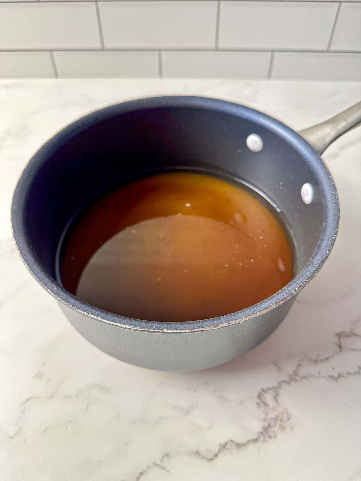 A small saucepan filled with brown sugar and water.