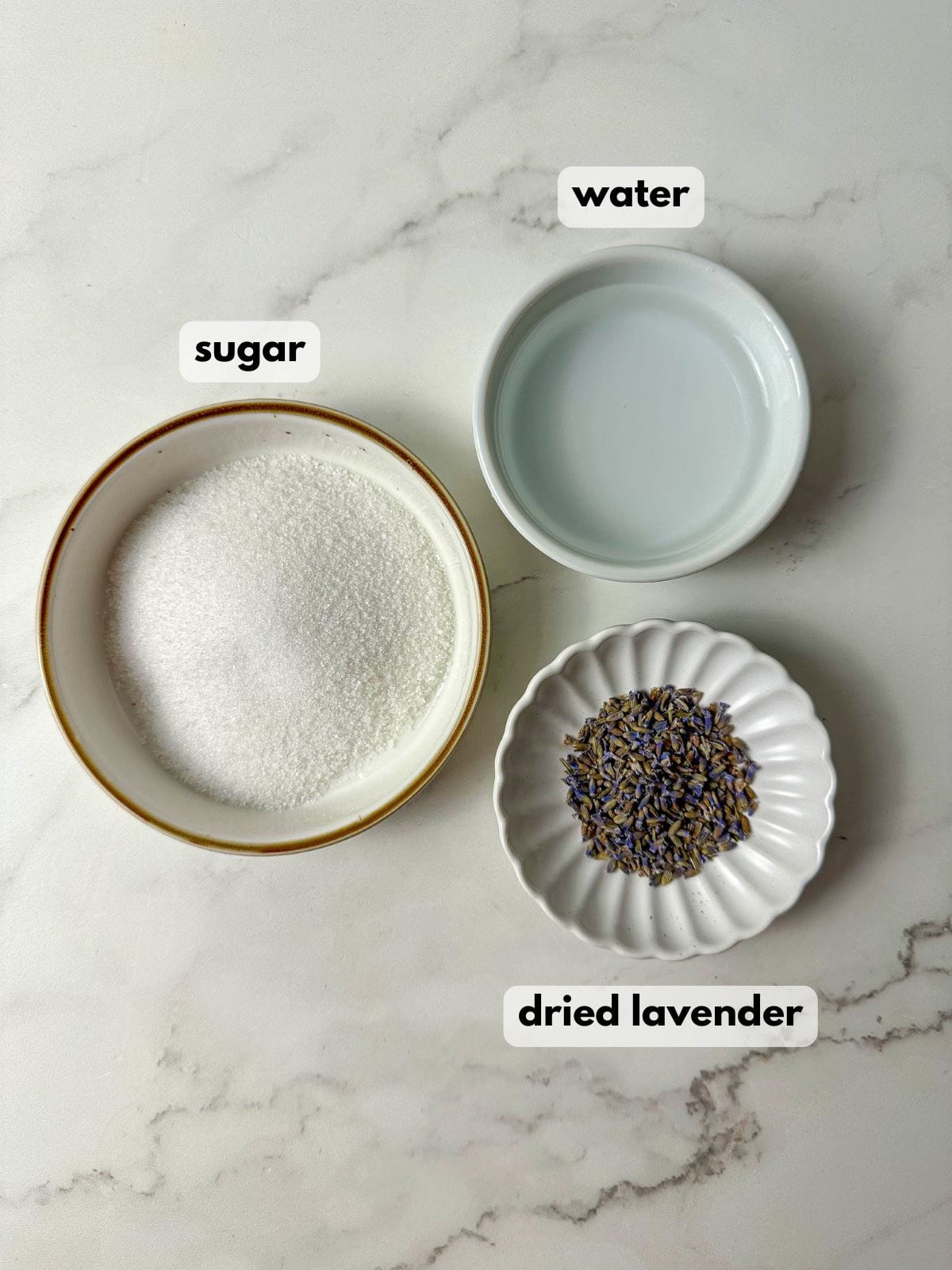 Three bowls filled with sugar, water, and dried lavender.