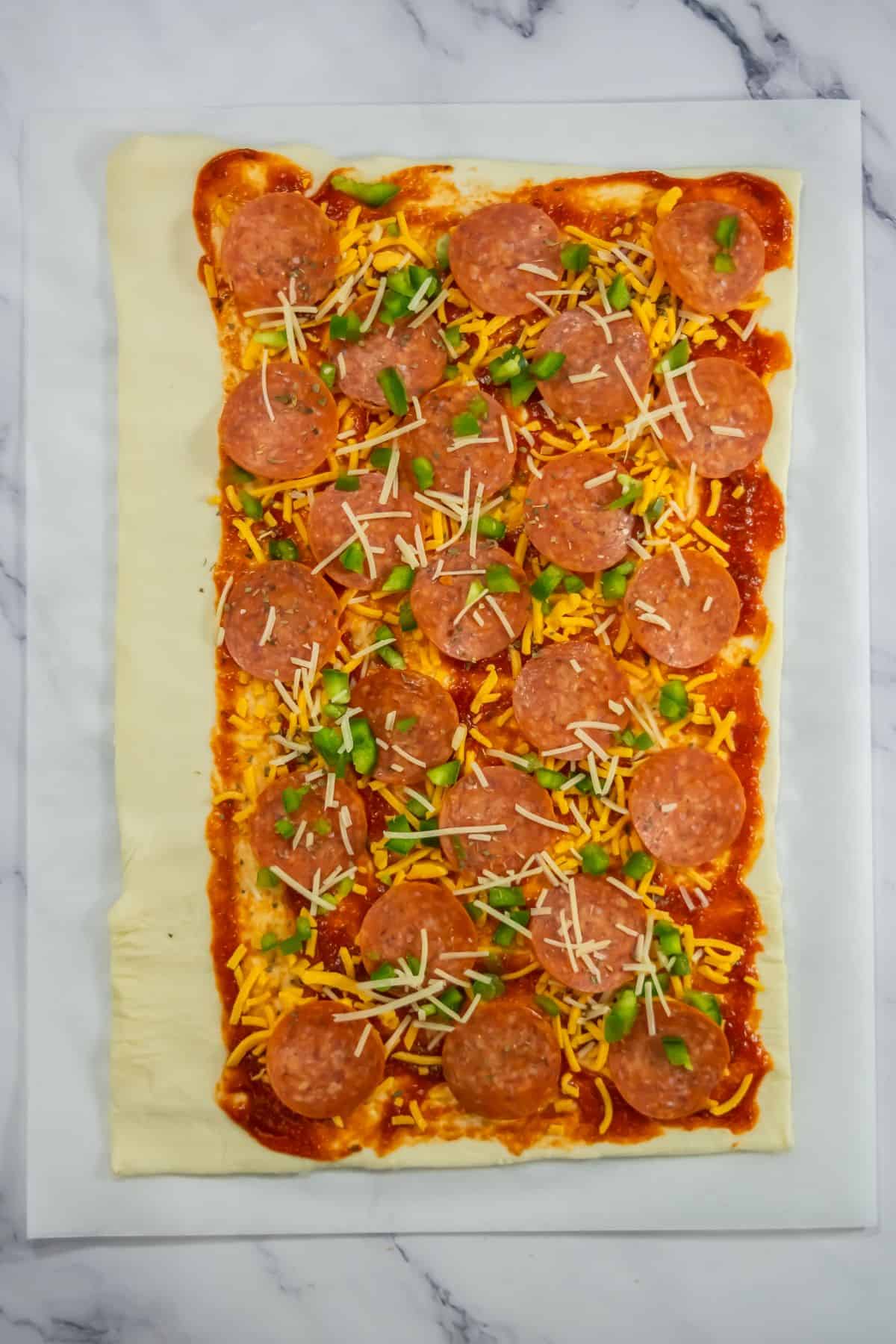 Puff pastry sheet topped with pepperoni, cheese, and marinara sauce.