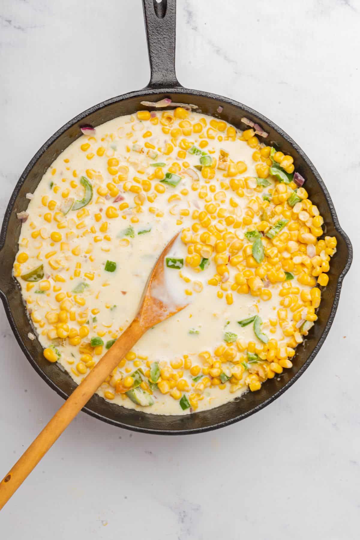 Heavy cream added to the skillet with corn and jalapenos.