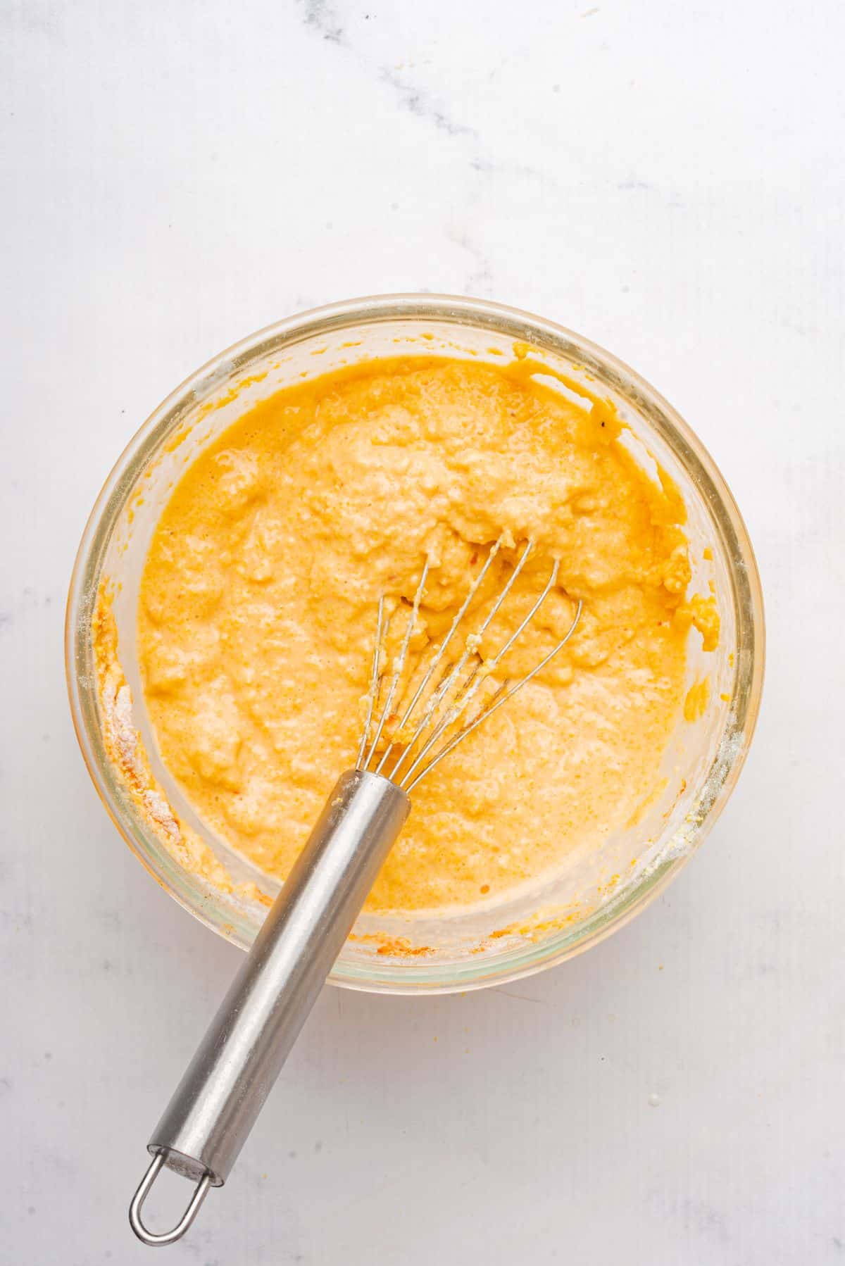 Jiffy corn muffin mix in a mixing bowl with a whisk.