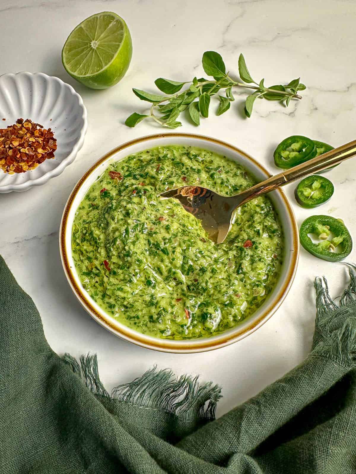 Cilantro jalapeno chimichurri sauce in a bowl with a spoon.